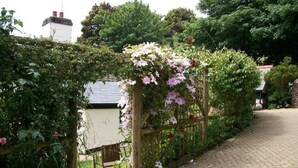 A garden pathway with a wooden trellis covered in flowering plants. - Your Sea View Studio with Balcony and Terrace - WIFI (strete)