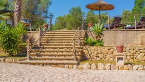A stone staircase leading up to a wooden deck with a thatched umbrella. - Son Monserrat, fantastic for two families. (Petra)