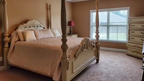 Een hemelbed met baldakijn, een kaptafel en een raam met zonwering.