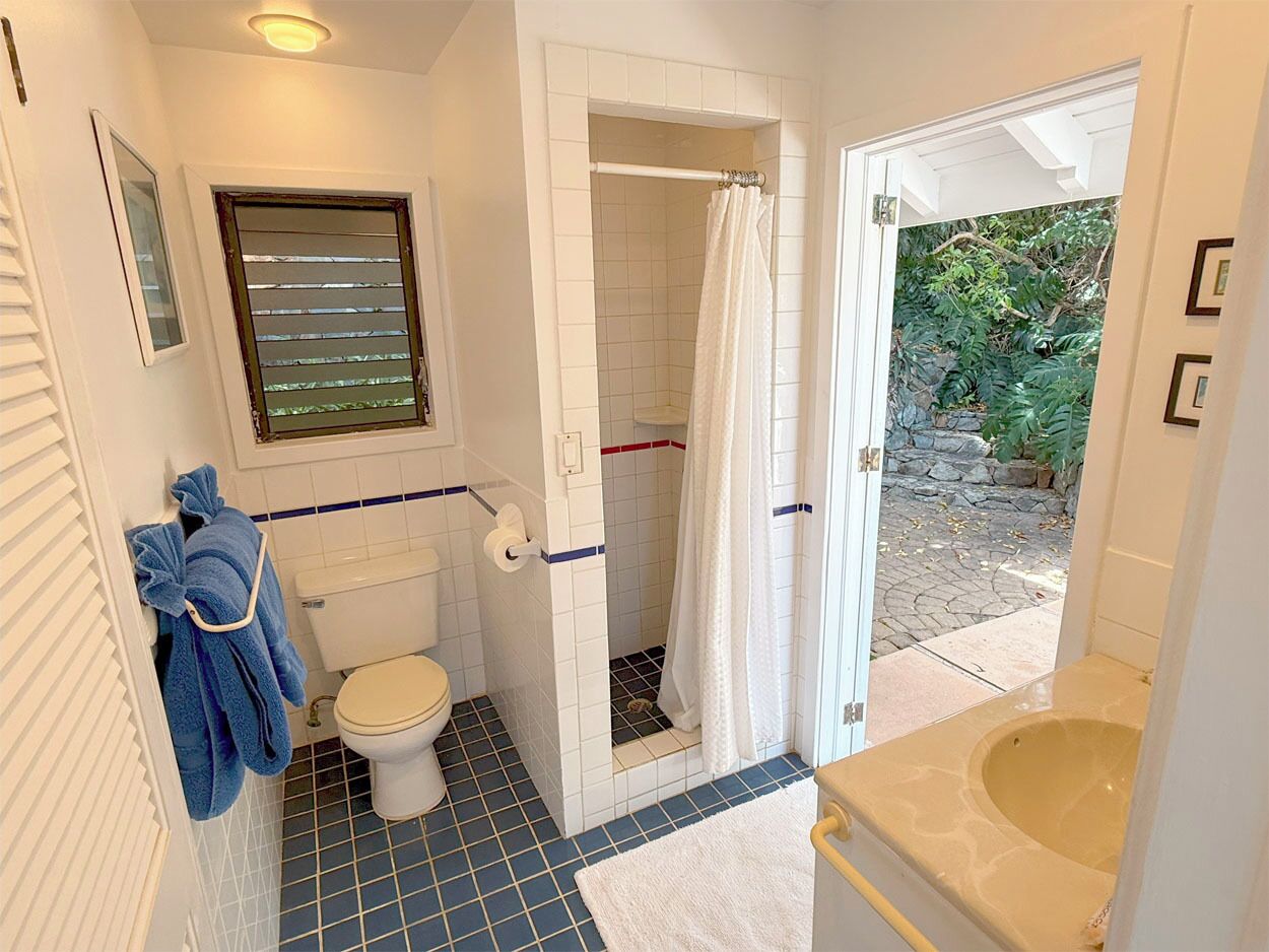 Een badkamer met toilet, douche en bad.