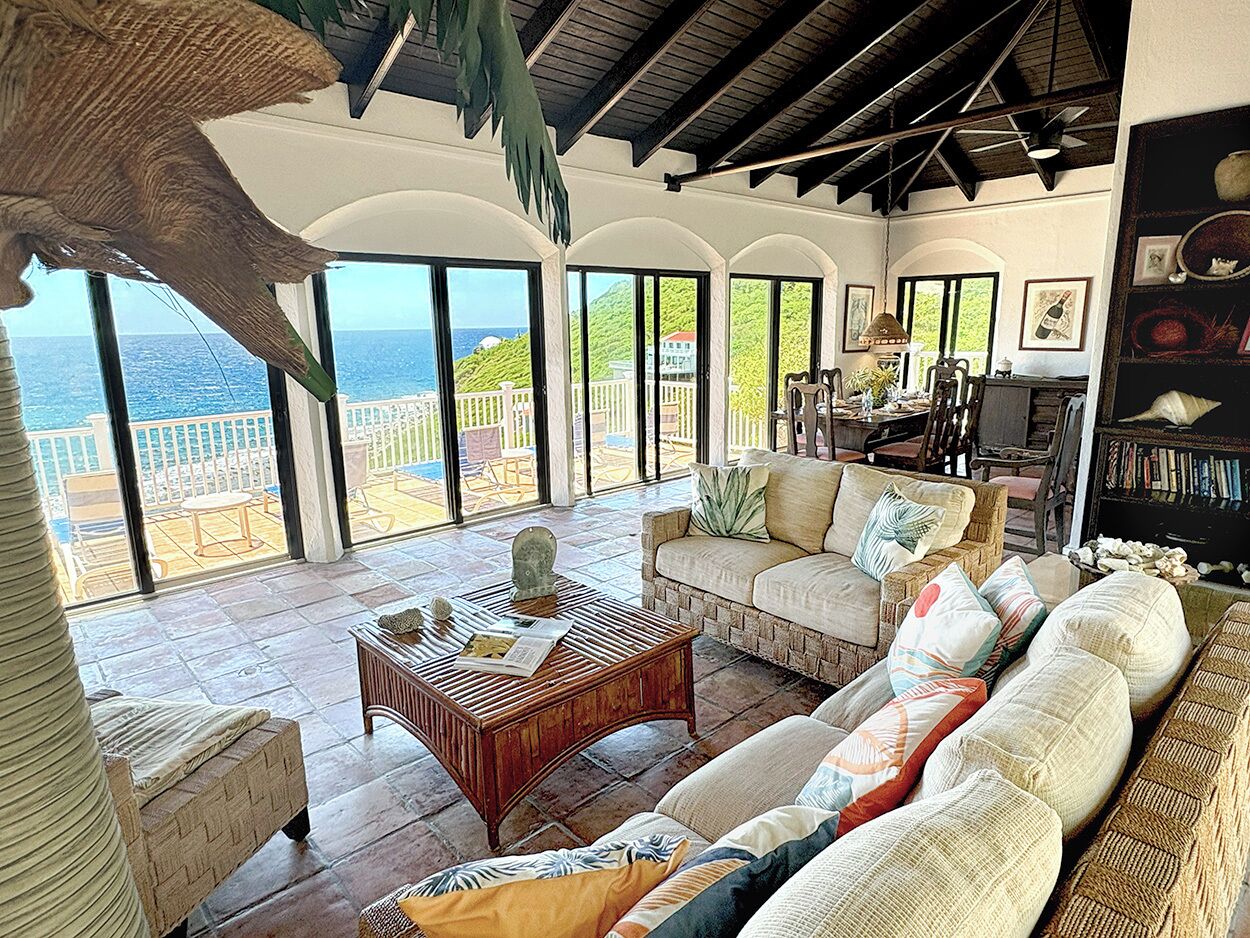 A spacious living area with a large window overlooking a scenic view, a comfortable sofa set, and a wooden coffee table.