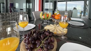 Ein Frühstückstisch mit Obst, Käse und Orangensaft.