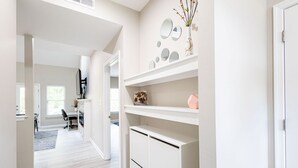 A modern, well-lit hallway with a desk and chair, white cabinetry, and decorative mirrors on the wall. - 5 Minutes to Boo Williams Sportsplex! Family-Fun Grotto Waterfall Bethel Oasis (Hampton)