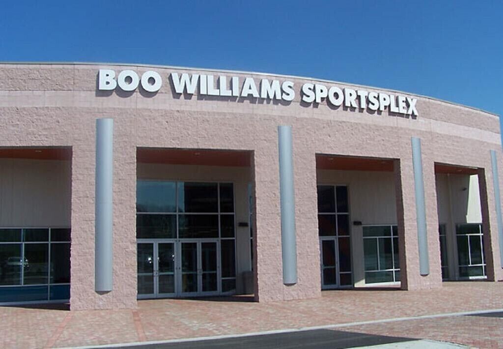 The exterior of Boo Williams Sportsplex with large glass doors and a flat roof.