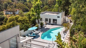 A modern house with a swimming pool, surrounded by lush greenery and a hilly landscape. - Beverly Hills Dream Home with pool and view hidden down private celebrity lane. (Beverly Hills)
