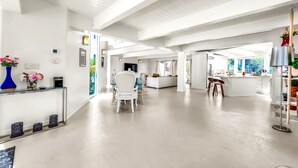 A spacious hotel lobby with a central seating area, a reception desk, and a view of the outdoors. - Beverly Hills Dream Home with pool and view hidden down private celebrity lane. (Beverly Hills)