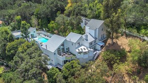 A large, modern house with a swimming pool, surrounded by dense forest. - Beverly Hills Dream Home with pool and view hidden down private celebrity lane. (Beverly Hills)