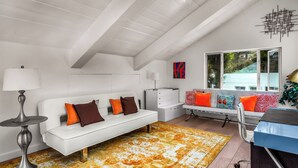 A modern interior with a white sofa, a patterned rug, and a window with a view. - Beverly Hills Dream Home with pool and view hidden down private celebrity lane. (Beverly Hills)