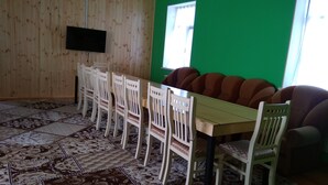 A conference room with a long table, white chairs, and a green wall. - About house......... (Quba)