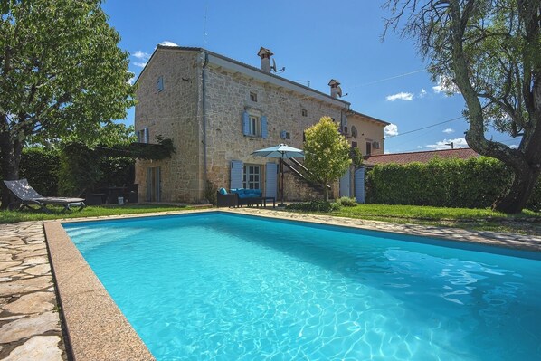 A stone building with a swimming pool, a covered outdoor seating area, and a garden. - Stone villa where pets are welcome and with private pool (Sveti Lovrec)