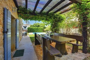A covered outdoor seating area with a pool in the background. - Stone villa where pets are welcome and with private pool (Sveti Lovrec)
