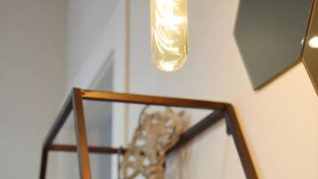 A geometric metal frame structure with a hanging light fixture and a decorative item inside.