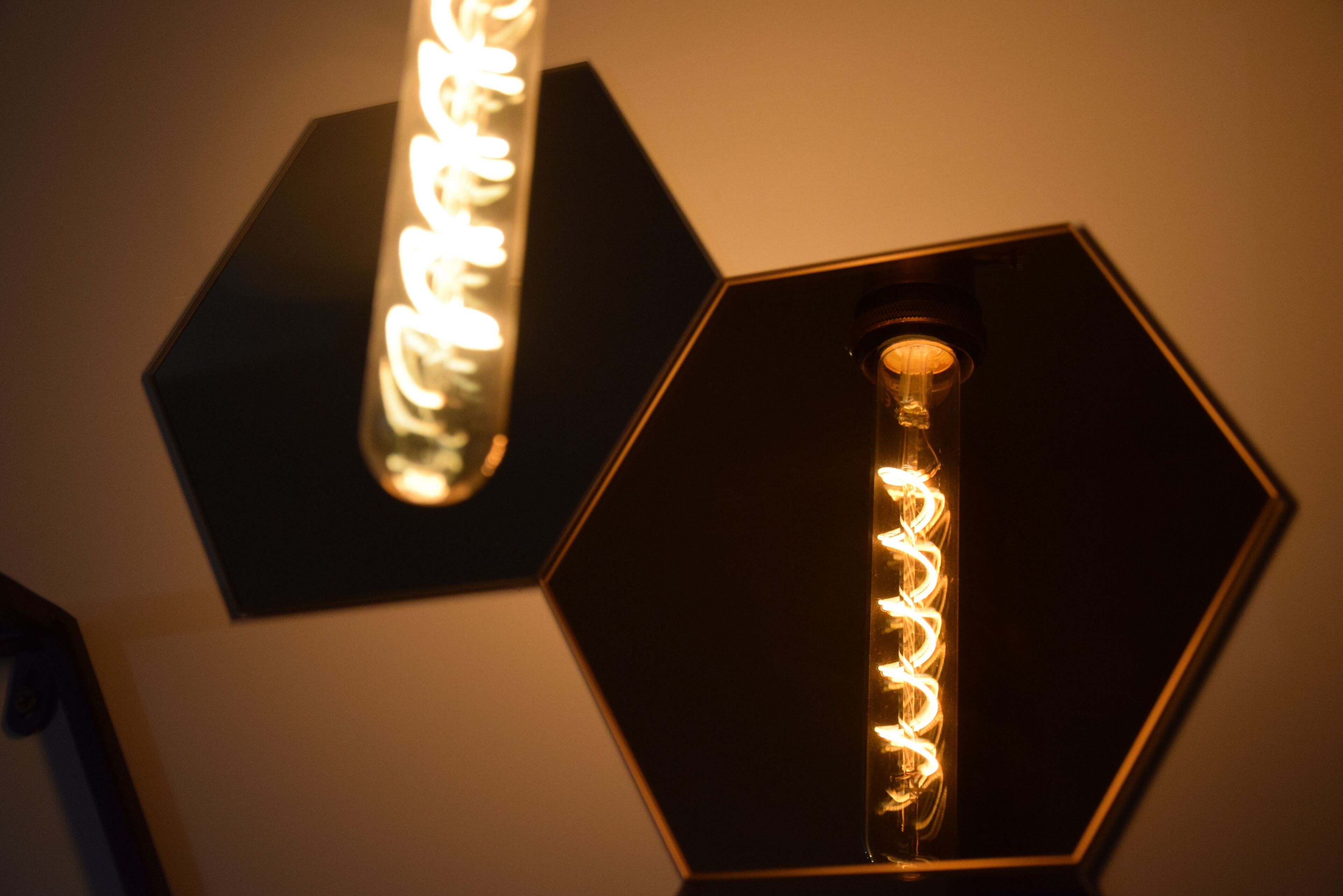 Dos lámparas hexagonales con diseños de luces en espiral.