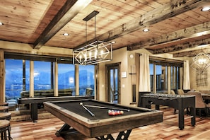 Enjoy a game of pool or foosball in this spacious indoor recreational area with a pool table, foosball table, and comfortable seating.