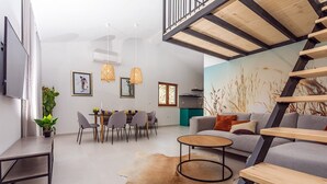 A modern living space with a dining area, a sofa, a coffee table, and a staircase. - Villa Remusic, Pool, whirlpool, Sauna,6 bedrooms, amazing landscape (Smolonje)