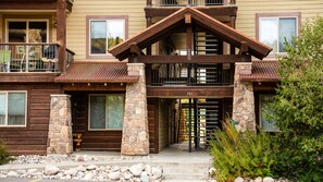 Experience the charm of this cozy cabin-style building with a welcoming stone archway and metal gate.