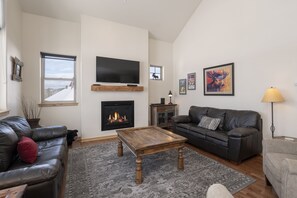 A living room with a fireplace, a television, and a sofa.