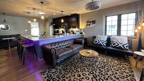 A modern living room with a leather sofa, a coffee table, and a leopard print rug. - Private house in a safe area, close to Nob Hill, UNM, Airport, Netflix, and KAFB (Albuquerque)
