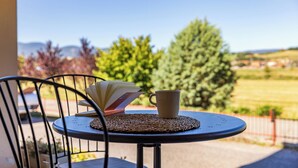 Ein runder Tisch mit einer gewebten Tischmatte, einem Buch und einer Tasse.
