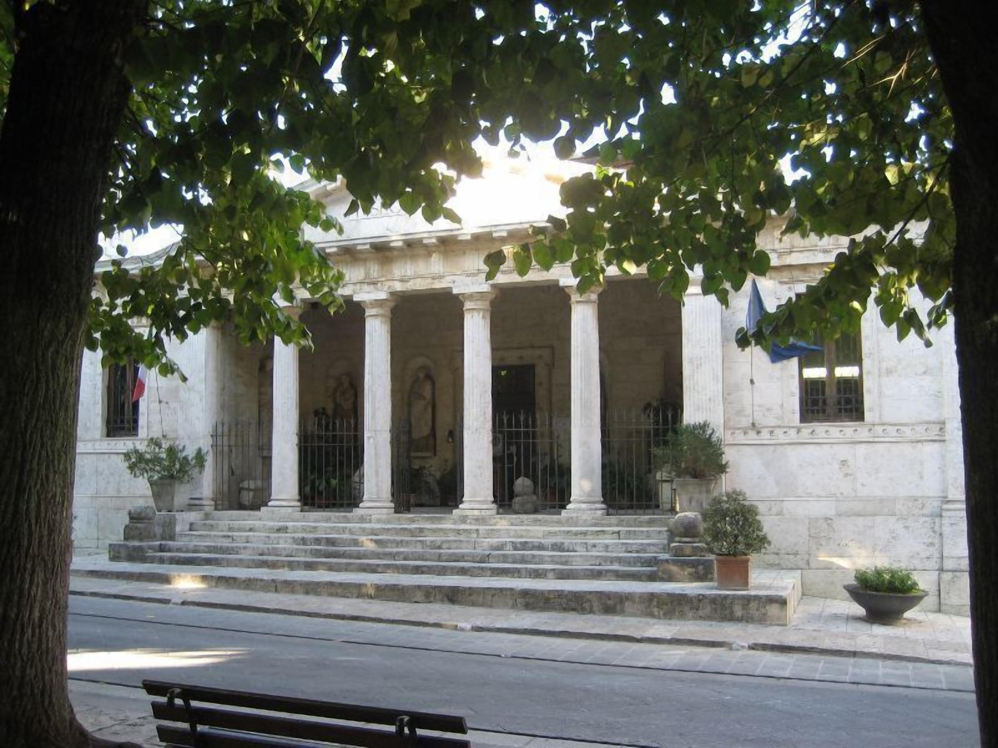 Un bâtiment à l’architecture classique, doté de colonnes et d’un escalier menant à une porte.