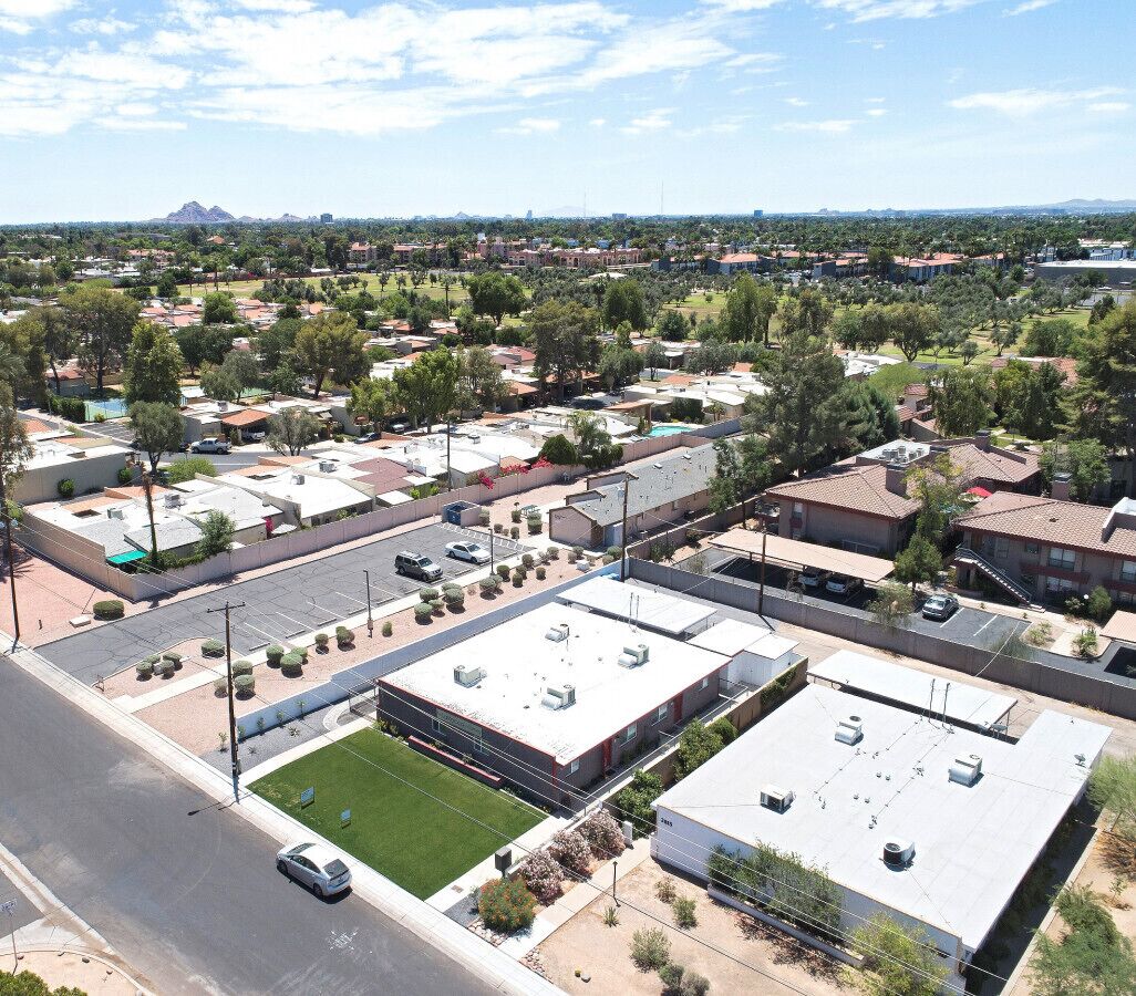 A residential area with multiple apartment buildings, a parking lot, and a road.