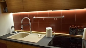 Una cucina con lavandino, bollitore e set da tè.