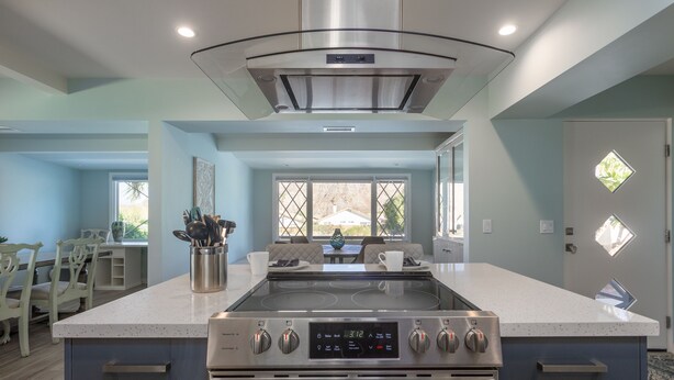 A modern kitchen with a central island, built-in oven, and stainless steel appliances. - Travel Back in Time to this Gorgeous 1950's Remodel (La Quinta,)