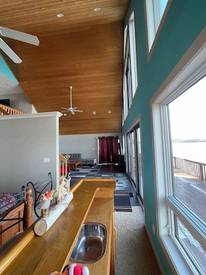 Una cocina con techo de madera, ventanas amplias y vistas al exterior.