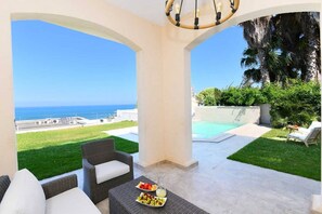 A covered outdoor area with a view of the ocean, a swimming pool, and outdoor furniture. - Villa '' Panorama '' (Gammarth)