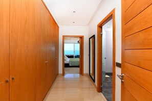 A hallway with wooden doors leading to a bedroom with a view of the sea. - Villa '' Panorama '' (Gammarth)