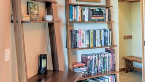 A room with a bookshelf containing various books and framed comic books. - Redwood | Japanese-Inspired Retreat by the Sea (Sea Ranch)
