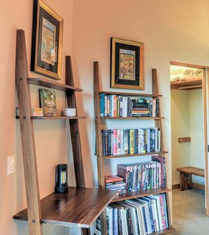 A room with a bookshelf containing various books and framed comic books. - Redwood | Japanese-Inspired Retreat by the Sea (Sea Ranch)