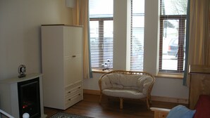 A living room with a fireplace, a sofa, a chair, and a small table. - Cooraclare apartment (Cooraclare)