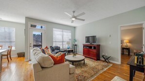 Una sala de estar con sofá, una mesa de centro y mueble rojo para entretenimiento.