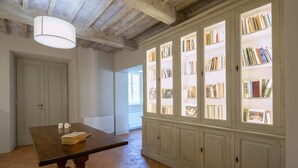 Een kamer met een houten tafel, boekenplanken en een deur.