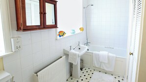 A bathroom with a white bathtub, a sink, and a mirror above the mirror cabinet. - 5 bedroom accommodation in East Ogwell, near Newton Abbot (East Ogwell, near Newton Abbot)