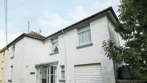 A two-story residential building with a garage door, a front door, and a small window. - 5 bedroom accommodation in East Ogwell, near Newton Abbot (East Ogwell, near Newton Abbot)