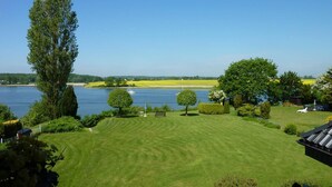 A well-maintained lawn with a clear view of a lake and distant land. - "Seeschwalbe" Vacation Rental in Kappeln (Kappeln)