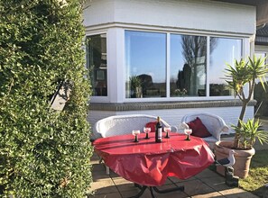 Relax in style with a bottle of wine and comfortable seating in this charming outdoor space.