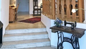 A staircase leading to a second floor, a wooden fence, a sewing machine, and framed pictures on the walls. - "Seeschwalbe" Vacation Rental in Kappeln (Kappeln)