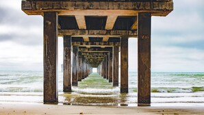 Une jetée qui s’avance dans l’océan, offrant une vue dégagée sur l’eau et le ciel.
