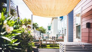 Un espace patio aménagé avec du mobilier d’extérieur, un petit jardin et un bâtiment en arrière-plan.