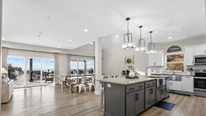 A modern kitchen with a large island, white cabinets, and stainless steel appliances. - Beautiful Lakeview 10 Bedrooms-hot tub/fire pit (Branson)