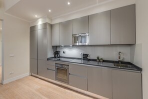 A modern kitchen with stainless steel appliances, a built-in oven, and a sleek countertop.