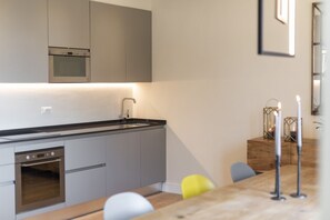 Eine moderne Küche mit integrierten Geräten, einem Holzespeisetisch und einem minimalistischen Design.