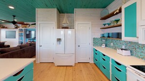 A kitchen with white cabinets, a wooden ceiling, and a tiled backsplash. - OV23 Shared Pool, Pet Friendly, Golf Cart Access (Port Aransas)