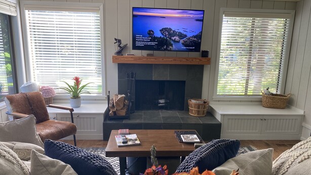 A living room with a fireplace, a television mounted above it, and a comfortable seating area with a coffee table. - Modern rustic condo in the heart of iconic Sun Valley (Sun Valley)