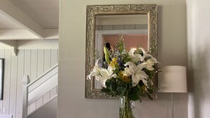 A white console table with a vase of flowers, a book, and a lamp. - Modern rustic condo in the heart of iconic Sun Valley (Sun Valley)