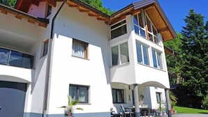 A two-story house with a balcony, large windows, and a garage. - Apartment Gabi by Interhome (Wenns)