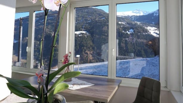 A room with a large window offering a view of a mountainous landscape. - Apartment Gabi by Interhome (Wenns)